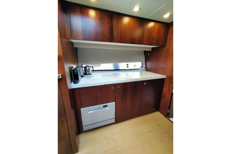  Yacht Photos Pics 2019 Fairline Targa 48 GT yacht kitchen with wood cabinets and modern appliances.