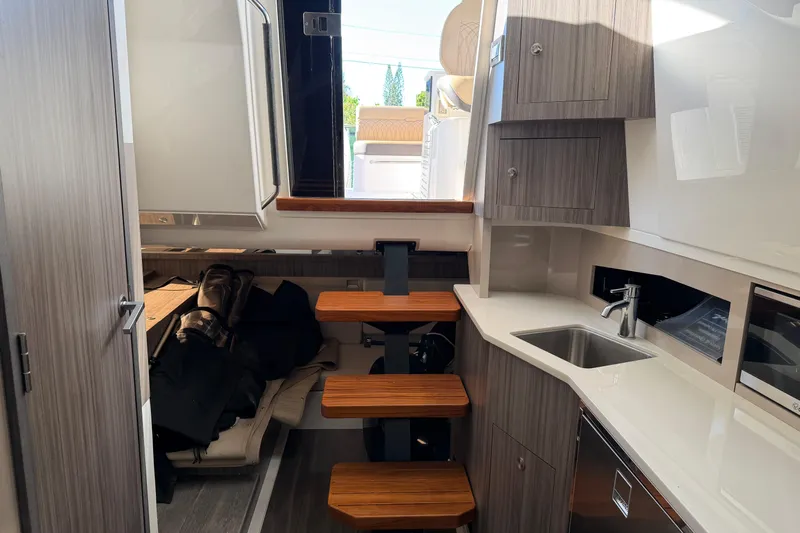  Yacht Photos Pics 2023 Sea Ray Sundancer 370 Outboard interior with kitchenette and wooden steps.