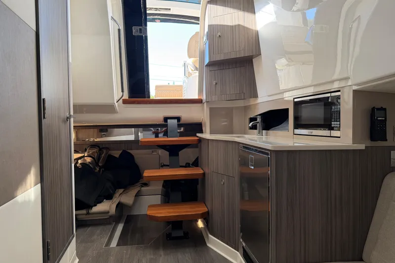 Yacht Photos Pics 2023 Sea Ray Sundancer 370 Outboard interior with modern kitchen and wooden steps.