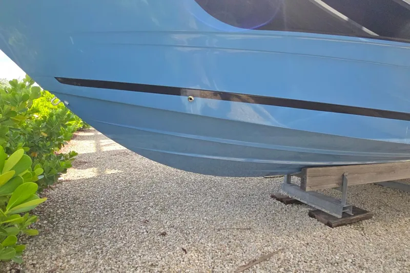  Yacht Photos Pics 2023 Sea Ray Sundancer 370 Outboard boat hull on gravel, side view.