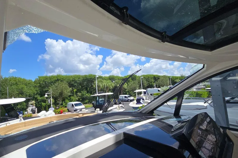  Yacht Photos Pics 2023 Sea Ray Sundancer 370 Outboard interior view with lush greenery and blue sky background.