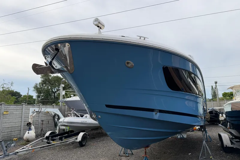  Yacht Photos Pics 2023 Sea Ray Sundancer 370 Outboard in storage, blue hull, parked on trailer.