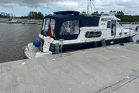 Nimbus 380 Commander 2007 yacht docked at marina, featuring blue canopy and German flag.