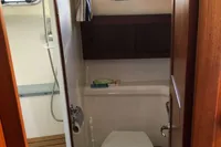 Nimbus 380 Commander 2007 boat bathroom with toilet, shower, and wooden accents.
