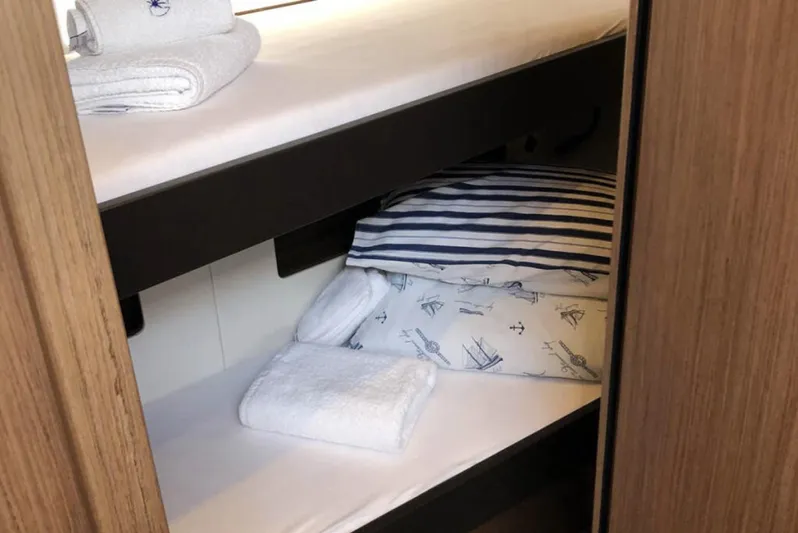 Penultimo Yacht Photos Pics Cozy cabin interior of 2021 Beneteau Oceanis Yacht 62 with neatly arranged bedding.