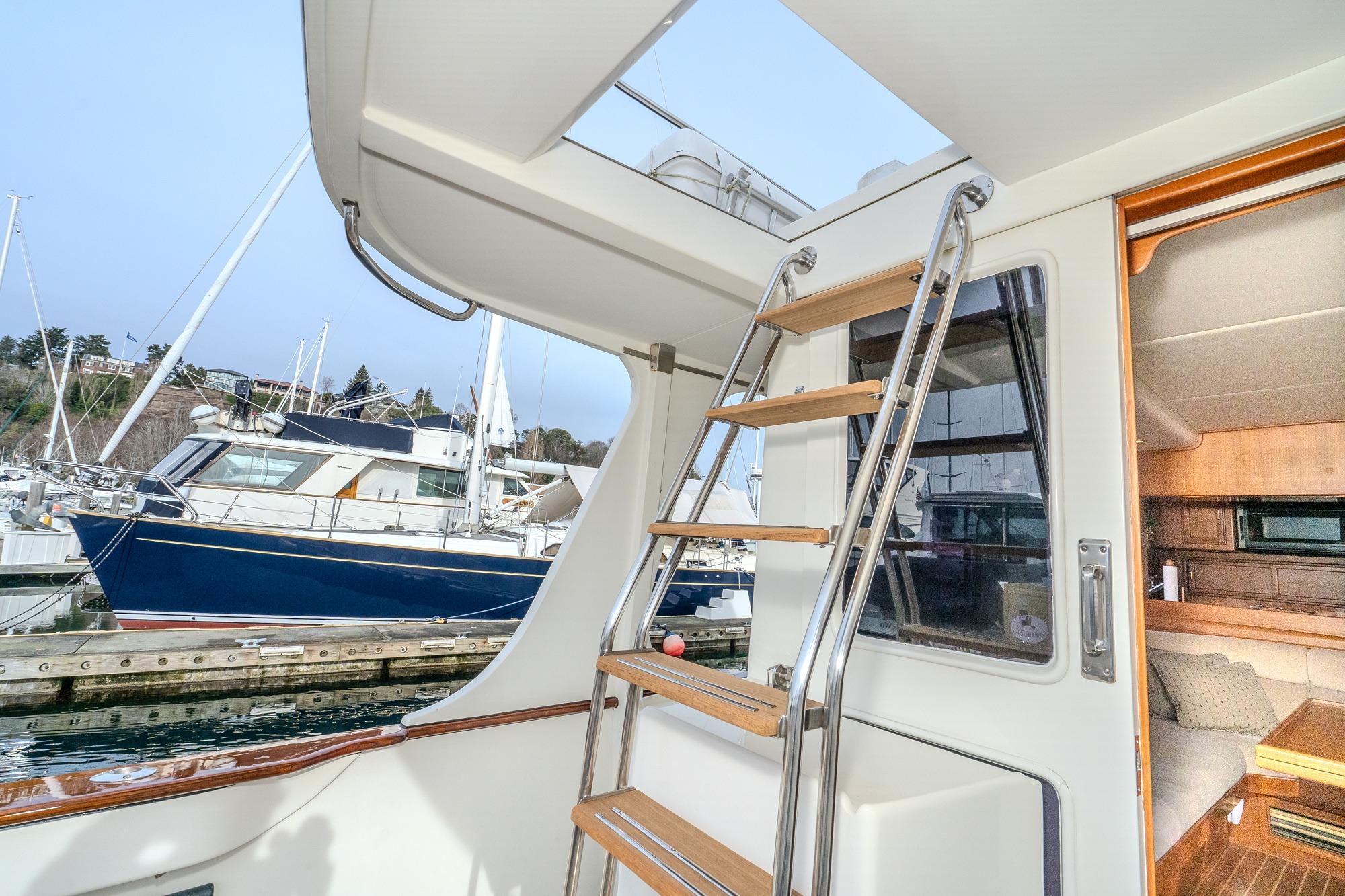 2001 Fleming 55 Pilothouse yacht interior with ladder and marina view.