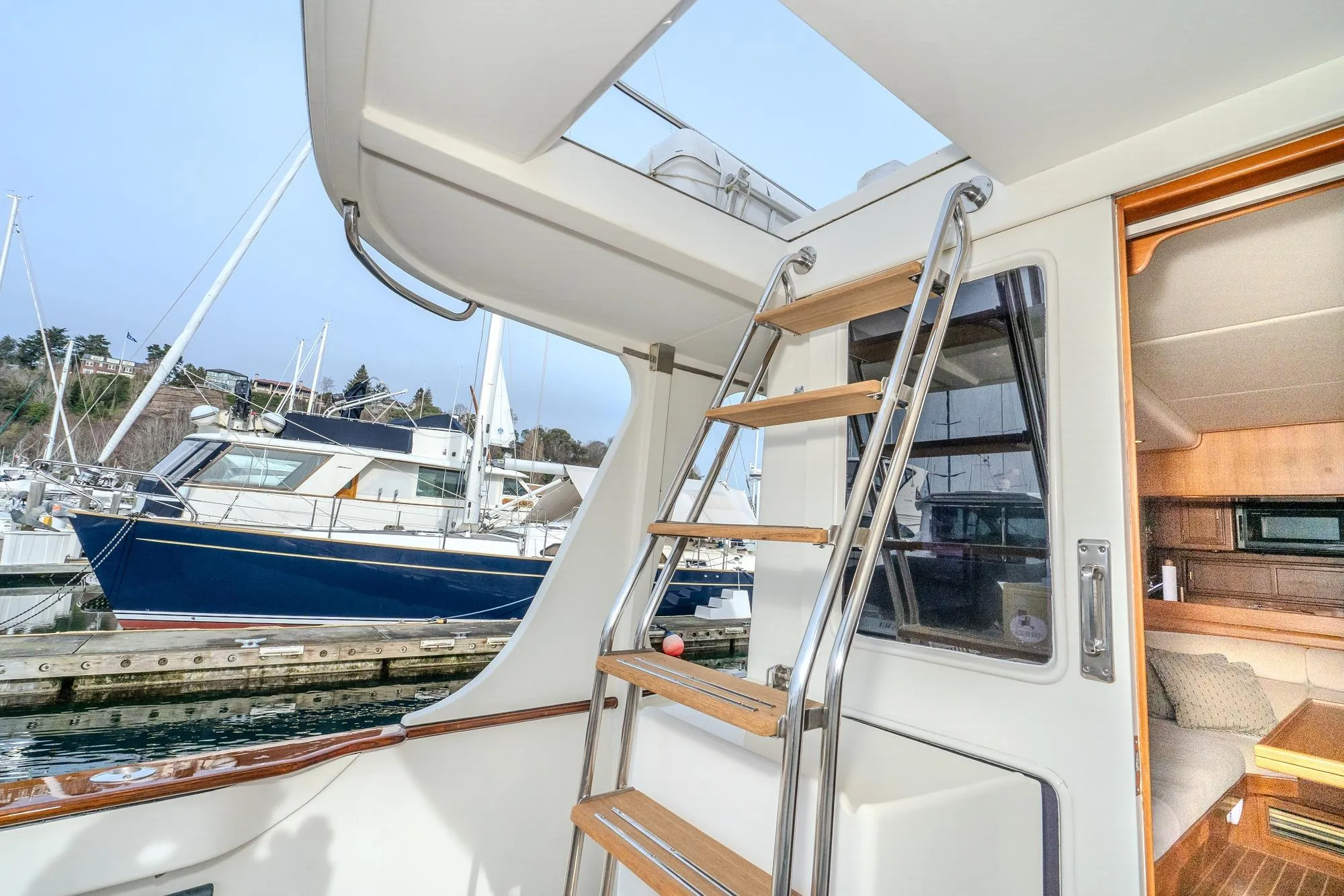 2001 Fleming 55 Pilothouse yacht interior with ladder and marina view.