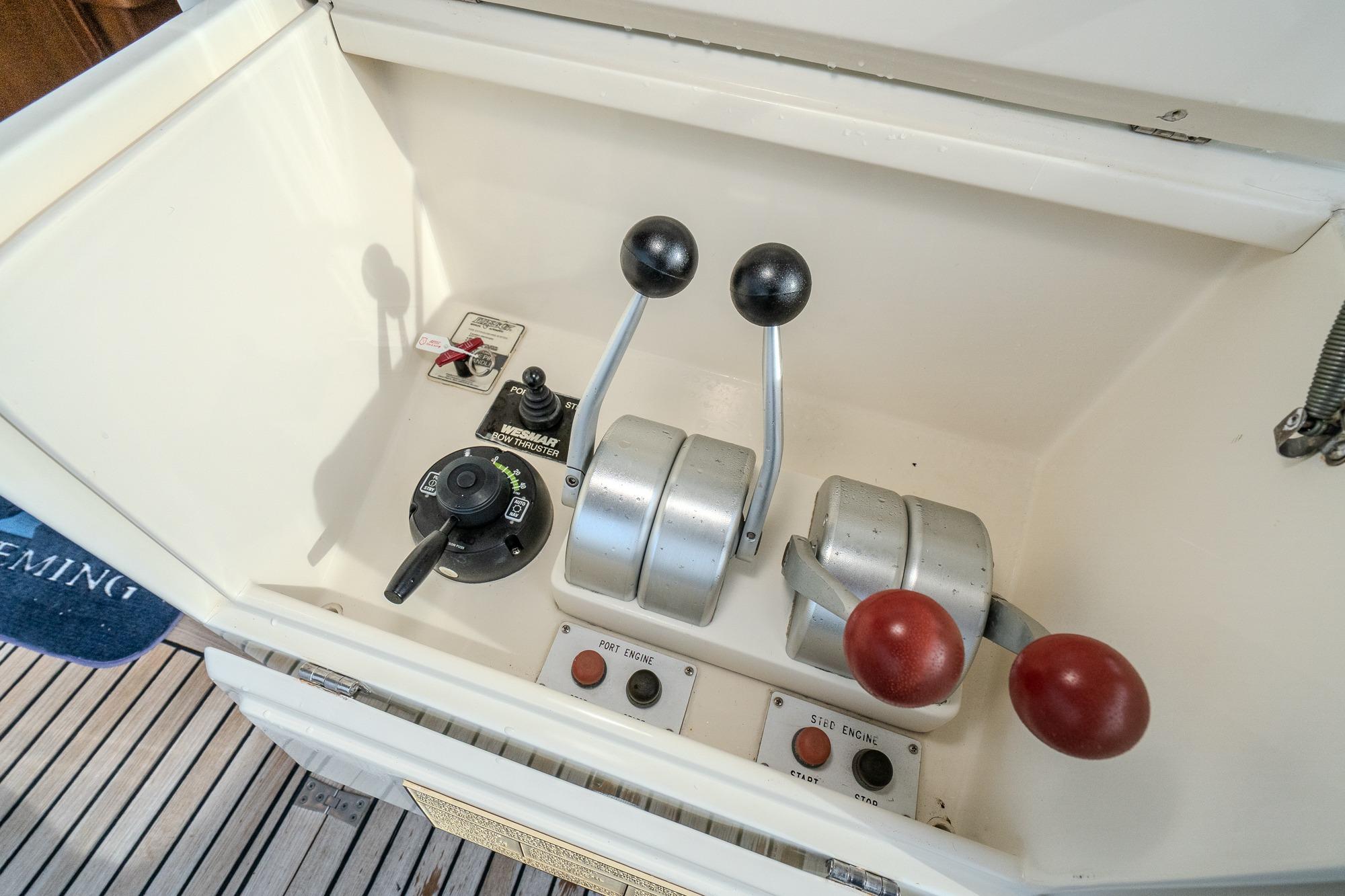 Control panel of a 2001 Fleming 55 Pilothouse yacht with throttle levers and switches.
