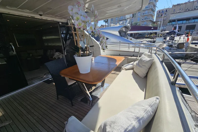 M/y Tivella Yacht Photos Pics Luxurious VZ 68 yacht deck with seating, table, and potted flowers, docked at marina.