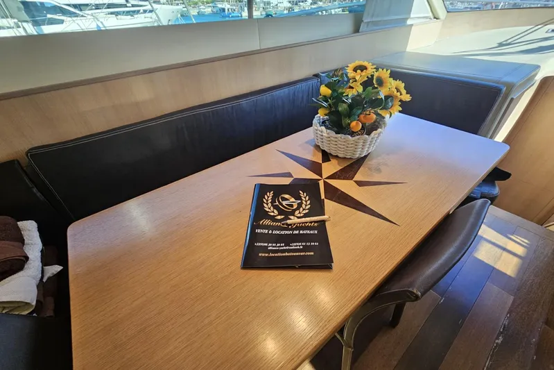 M/y Tivella Yacht Photos Pics Luxurious VZ 68 yacht interior with wooden table, floral centerpiece, and brochure, 2009 model.