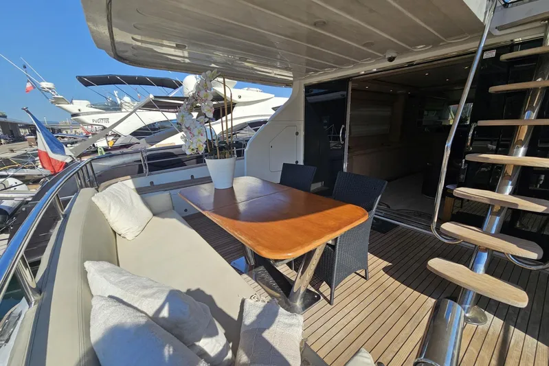 M/y Tivella Yacht Photos Pics Outdoor seating area on a 2009 VZ 68 yacht, featuring a wooden table and cushioned bench.