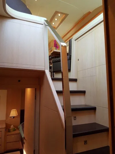M/y Tivella Yacht Photos Pics Interior staircase of a 2009 VZ 68 yacht, featuring modern wood paneling and sleek design.