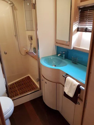 M/y Tivella Yacht Photos Pics Luxurious bathroom in 2009 VZ 68 yacht with modern shower and sleek blue countertop.