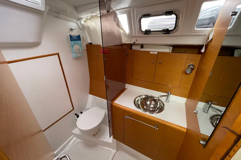 Eclipse Yacht Photos Pics 2014 Jeanneau Sun Odyssey 439 bathroom with wooden cabinets, sink, and toilet.