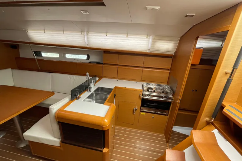 Eclipse Yacht Photos Pics 2014 Jeanneau Sun Odyssey 439 interior with kitchen, dining area, and wooden cabinetry.