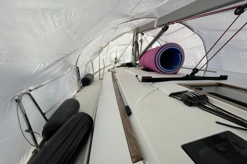 Eclipse Yacht Photos Pics 2014 Jeanneau Sun Odyssey 439 sailboat deck under protective cover, with rolled mats and equipment.
