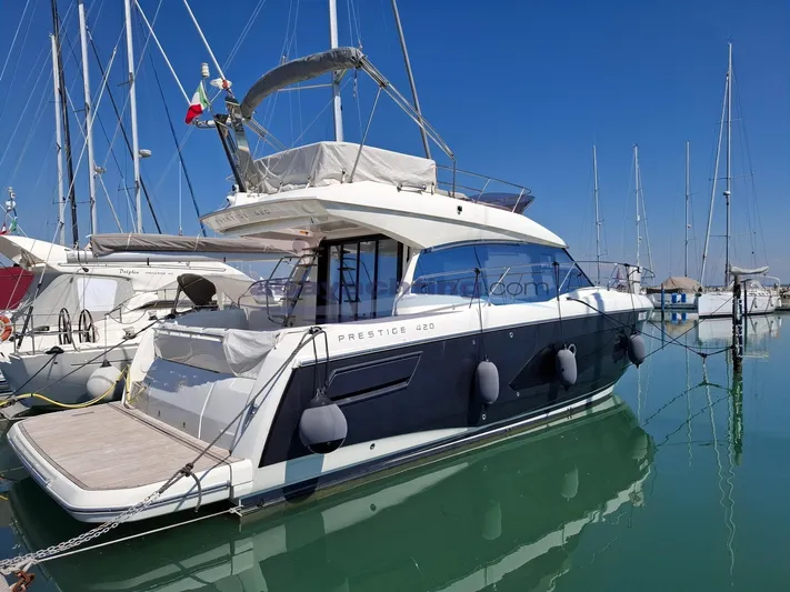 Yacht Photos Pics 2019 Prestige 420 Flybridge yacht docked in a marina, reflecting on calm water.