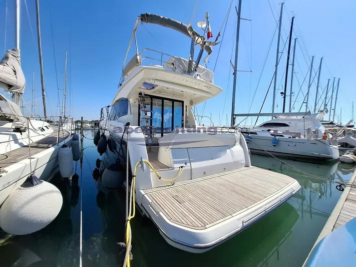 Yacht Photos Pics 2019 Prestige 420 Flybridge yacht docked in a marina, surrounded by other boats.