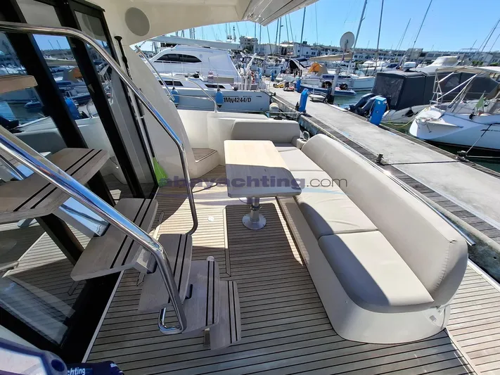  Yacht Photos Pics 2019 Prestige 420 Flybridge yacht with elegant seating and table on deck.