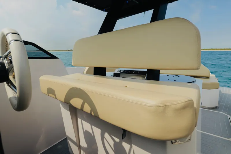  Yacht Photos Pics 2023 Rio Yachts Daytona 34 helm with beige seating, steering wheel, and ocean backdrop.
