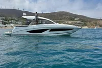 2024 Bavaria Sport 36 Open yacht on clear blue water, coastal hills in background.