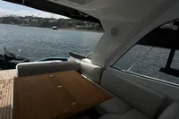 2024 Bavaria Sport 36 Open yacht interior with wooden table and seating, overlooking serene waters.
