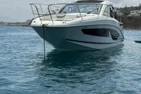 2024 Bavaria Sport 36 Open yacht anchored on calm blue water under a cloudy sky.