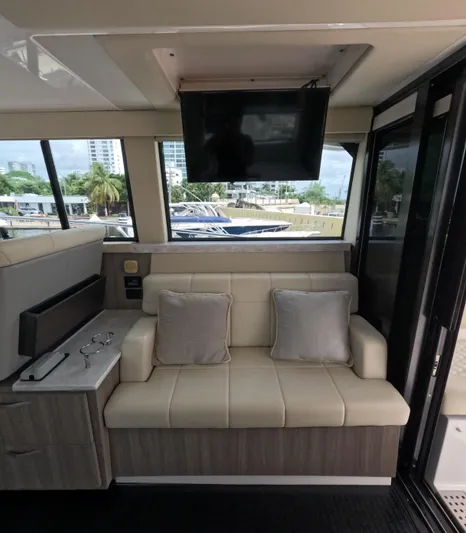  Yacht Photos Pics Interior of 2020 Regal Grande Coupe 38' yacht with beige seating and mounted TV.