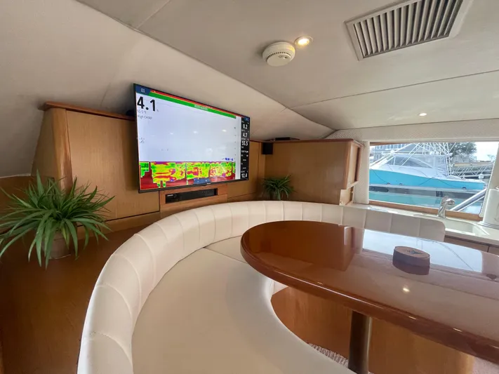 Rainmaker Yacht Photos Pics Luxurious interior of 2004 Ocean Yachts 40 SS with curved seating and mounted TV.