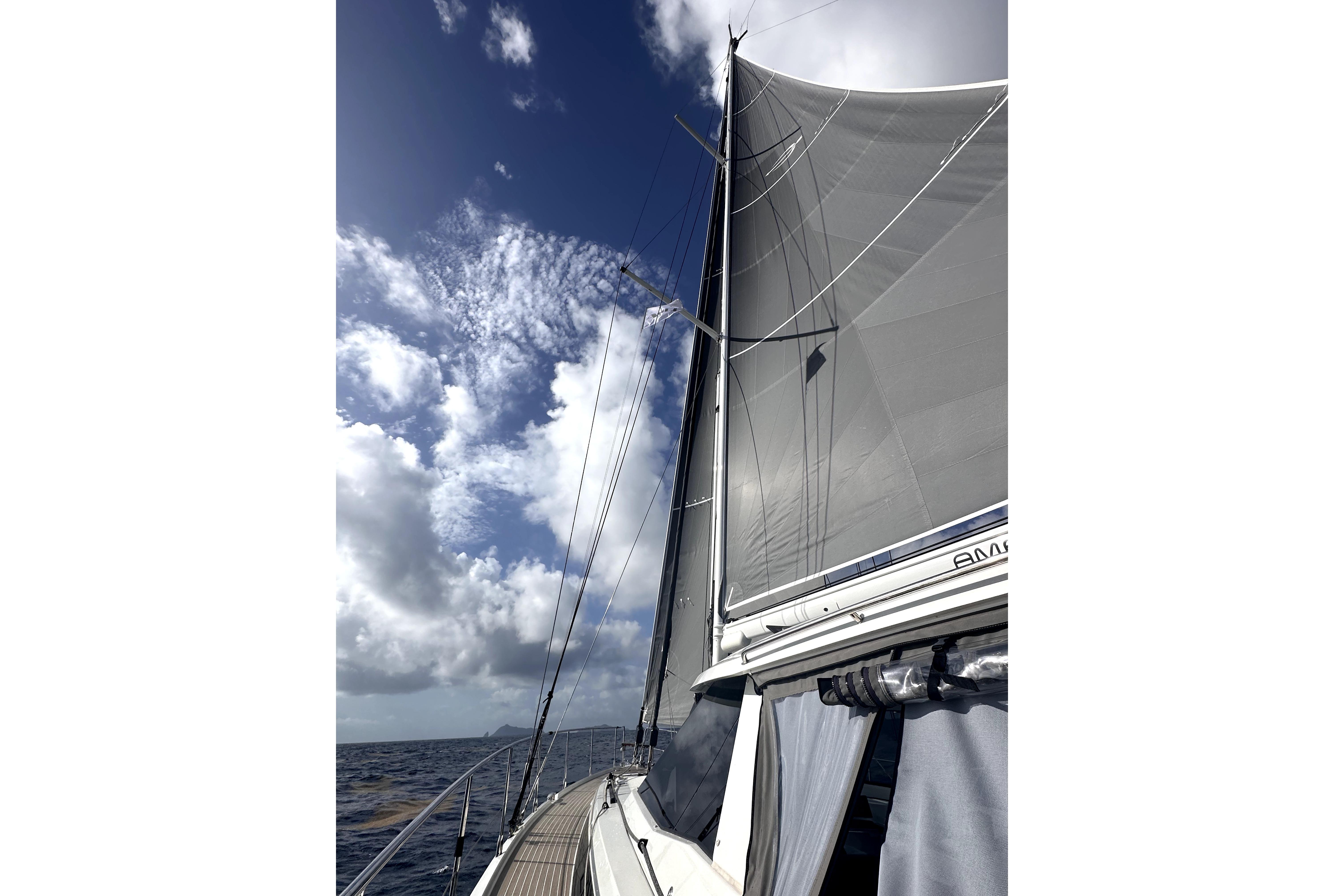 Sailing on a 2024 Amel 50 yacht under a clear blue sky.