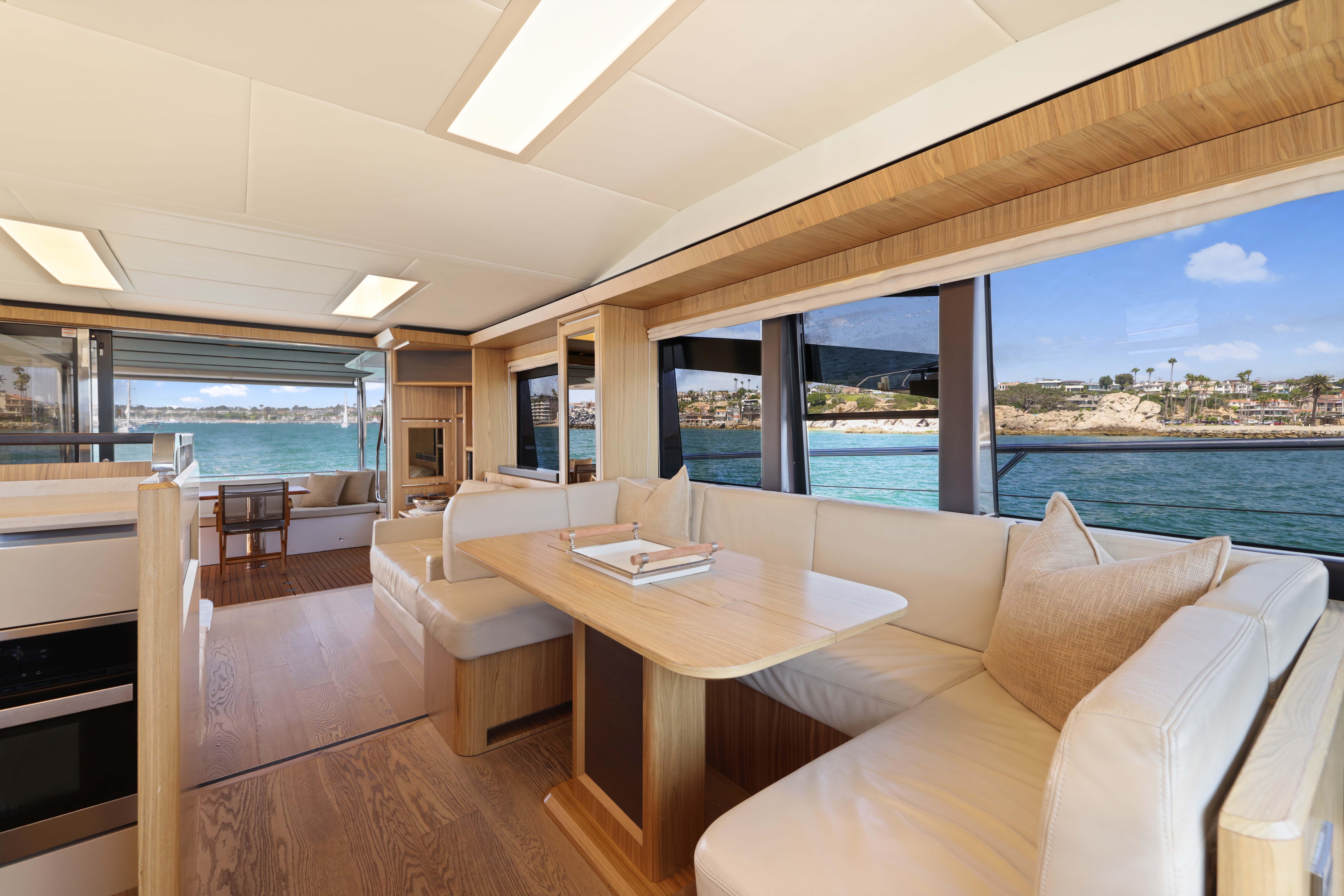 Luxurious yacht interior with ocean view, featuring elegant seating and dining area.