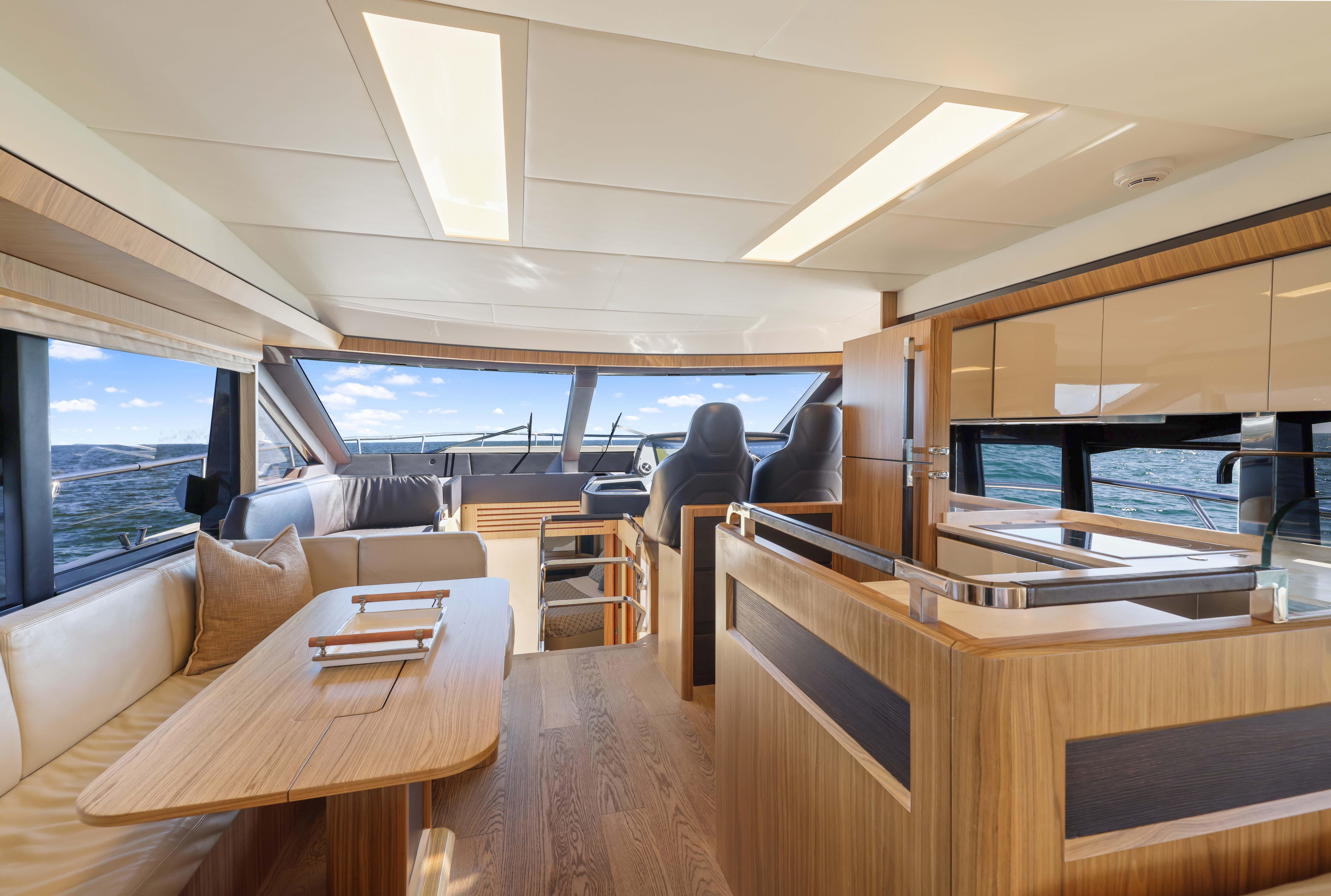 Luxurious yacht interior with modern wood finishes, spacious seating, and ocean view. Absolute Fly Co Ownership 2015.