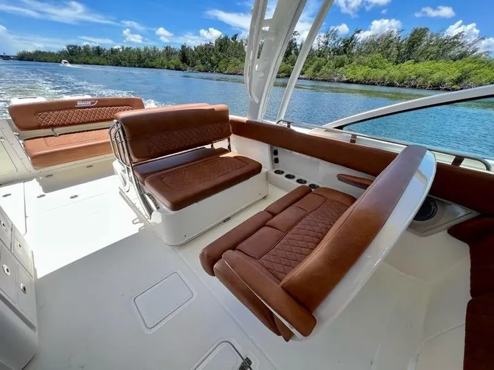 Getting There Yacht Photos Pics 2017 Boston Whaler Vantage 320 boat interior with brown leather seating, cruising on a sunny day.
