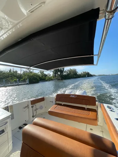 Getting There Yacht Photos Pics 2017 Boston Whaler Vantage 320 cruising on a sunny day, featuring comfortable seating and canopy.