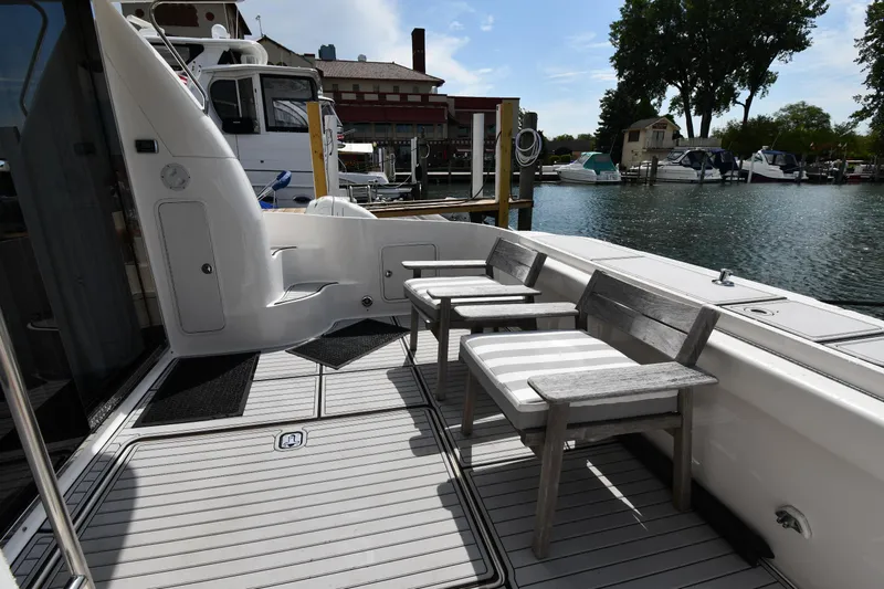 007 Yacht Photos Pics 2001 Sea Ray 480 Sedan Bridge yacht deck with chairs, docked at marina.