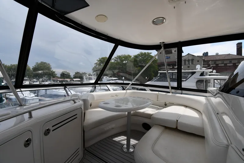 007 Yacht Photos Pics 2001 Sea Ray 480 Sedan Bridge interior with seating and table, docked at marina.
