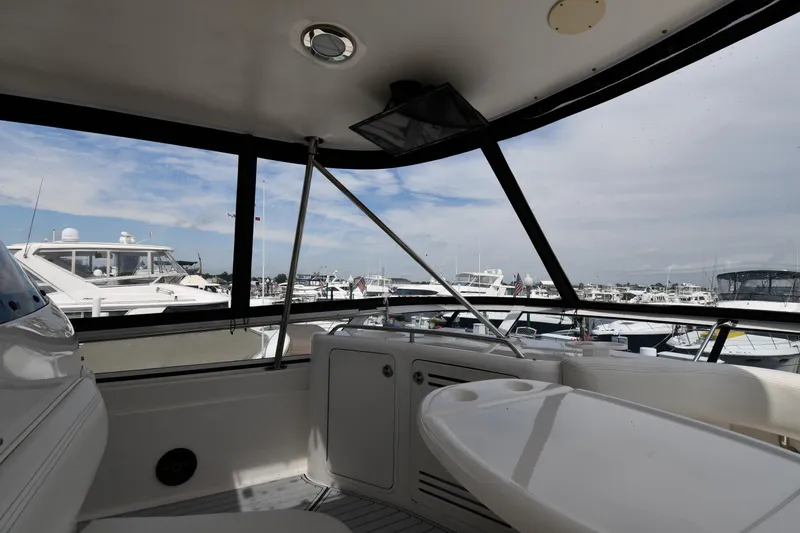 007 Yacht Photos Pics 2001 Sea Ray 480 Sedan Bridge interior with marina view, featuring seating and table.