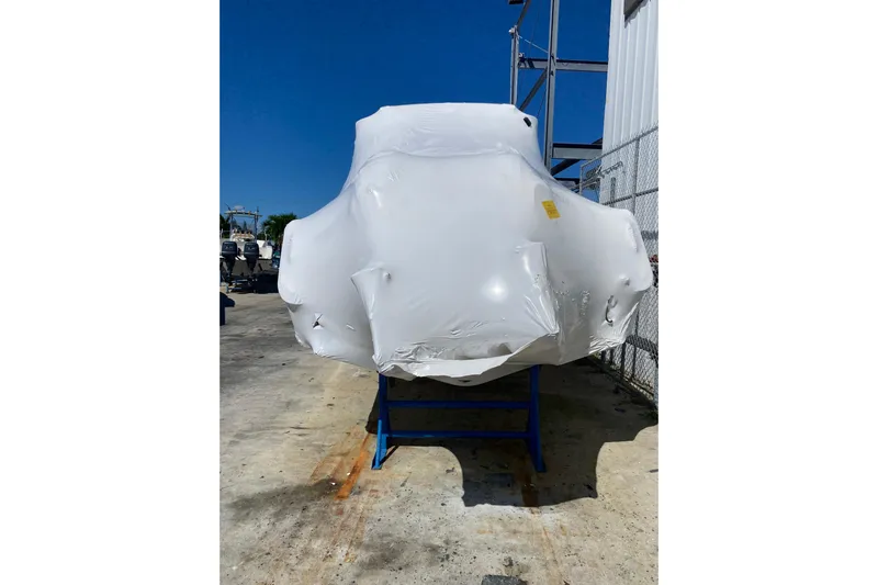  Yacht Photos Pics 2026 Grady-White Canyon 306 boat wrapped in protective covering, outdoor storage.