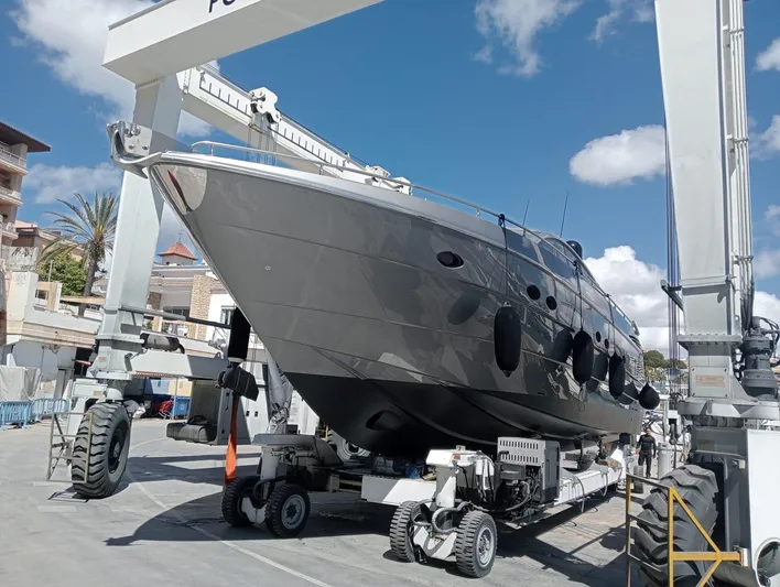 Oxygen III Yacht Photos Pics 2007 Pershing 56 yacht in dry dock, lifted by crane under a clear blue sky.