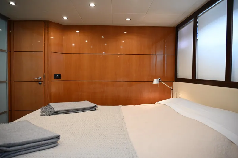 Oxygen III Yacht Photos Pics Luxurious bedroom interior of 2007 Pershing 56 yacht with wooden paneling and cozy bedding.