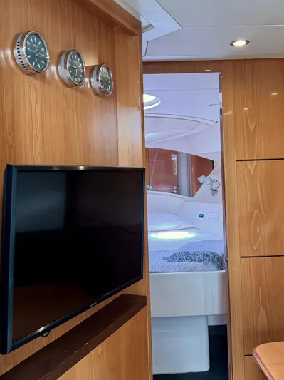 Oxygen III Yacht Photos Pics Interior of 2007 Pershing 56 yacht with wood paneling, wall-mounted TV, and cabin view.