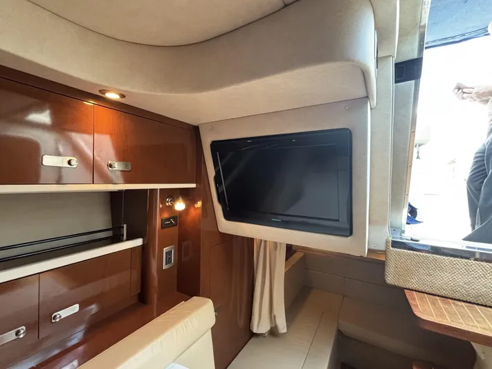 Mocaccino Yacht Photos Pics Interior of 2011 Sea Ray 350 Sundancer with TV, wooden cabinets, and seating area.