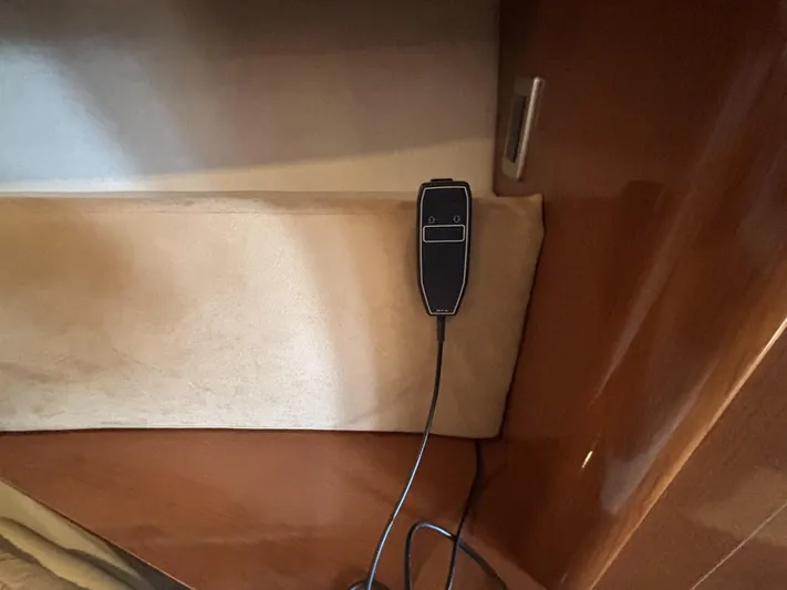 Mocaccino Yacht Photos Pics Remote control in a 2011 Sea Ray 350 Sundancer cabin, mounted on a wooden panel.