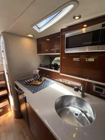 Mocaccino Yacht Photos Pics 2011 Sea Ray 350 Sundancer kitchen with sink, microwave, and wooden cabinetry.