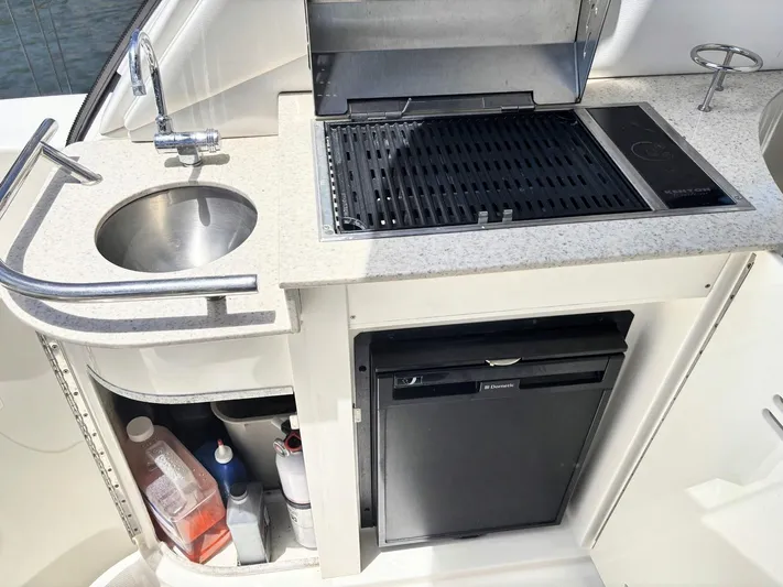 Mocaccino Yacht Photos Pics Outdoor kitchenette on 2011 Sea Ray 350 Sundancer with sink, grill, and mini fridge.