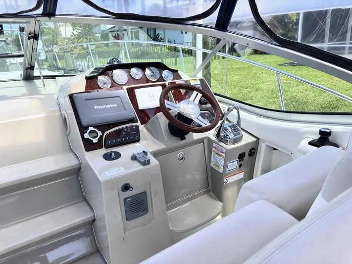 Mocaccino Yacht Photos Pics 2011 Sea Ray 350 Sundancer helm with steering wheel, navigation system, and control panel.