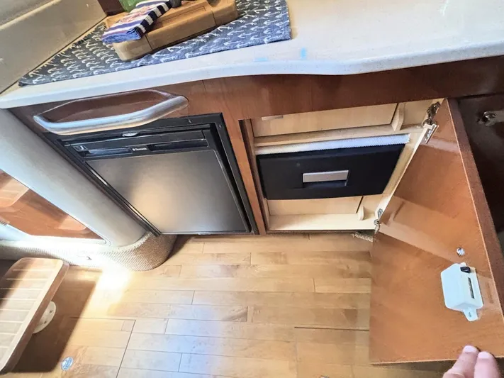 Mocaccino Yacht Photos Pics Interior of 2011 Sea Ray 350 Sundancer showing kitchenette with fridge and open cabinet.