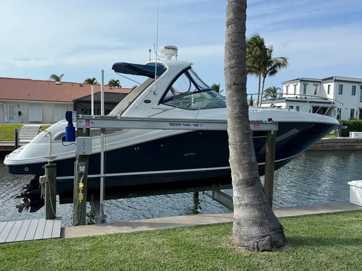Mocaccino Yacht Photos Pics 2011 Sea Ray 350 Sundancer yacht docked by waterfront homes, palm trees in background.