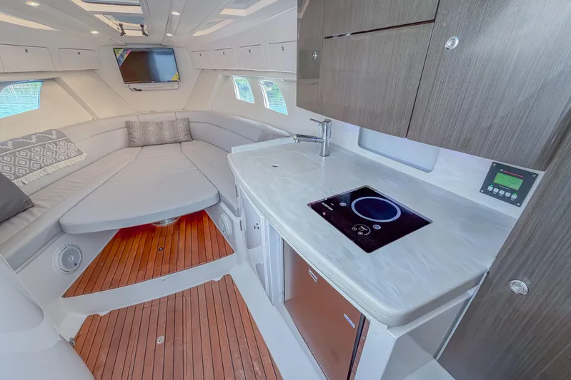  Yacht Photos Pics Luxurious interior of 2018 Intrepid 407 Cuddy with modern kitchenette and cozy seating area.