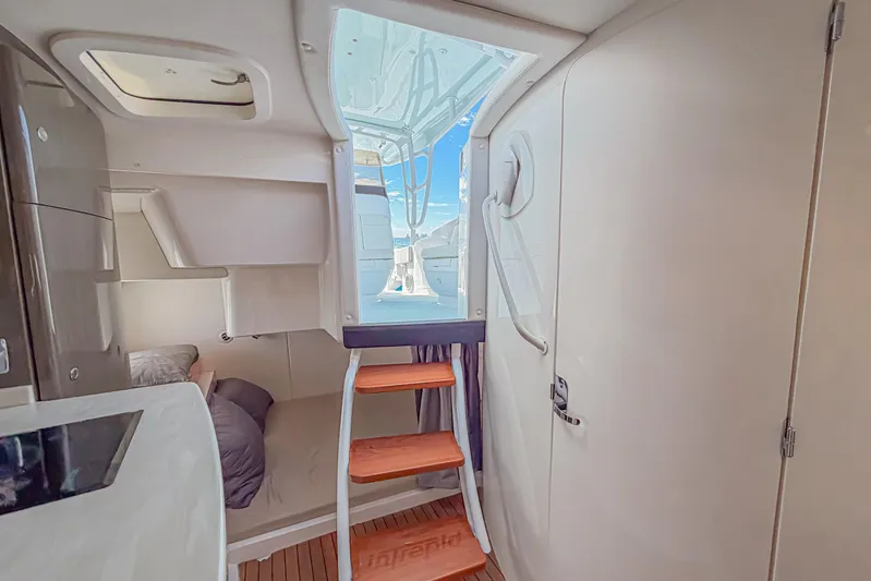  Yacht Photos Pics Interior view of 2018 Intrepid 407 Cuddy with wooden steps and cozy cabin space.